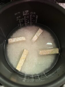 炊飯器の中に、研いだお米、水、課っとしたテンペが入っている状態。