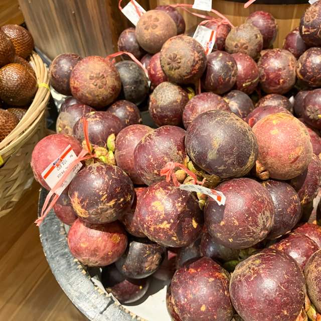 スーパーでうられているマンゴスチン Mangiss。赤みの強い茶色の丸い果物。ゴルフボールより大きく、テニスボールより小さい。