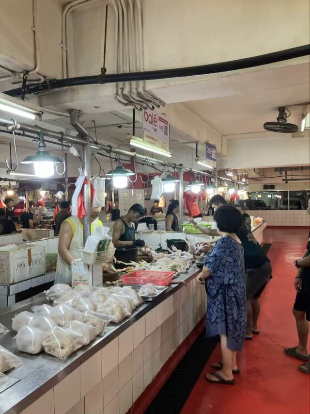 PIKフレッシュマーケットの肉を売っている場所。一羽ずつ袋詰めにされた鶏肉がずらりと並んでいて、奥では店員さんが肉をカットしている
